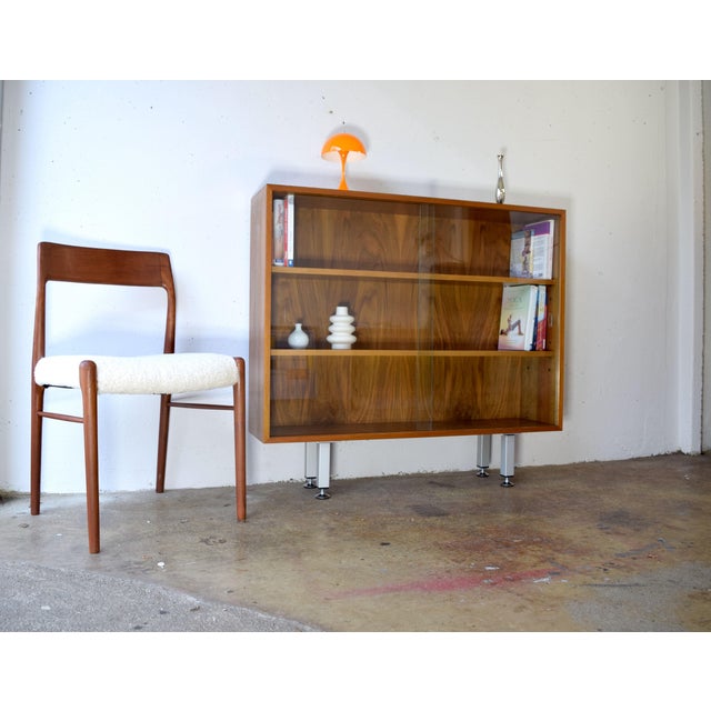 This is a simple display cabinet from the 1960s. The combination of glass, wood, and metal makes it a timeless classic....