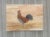 This charming rooster stands proudly against a warm sunrise backdrop. Rich earth tones and soft washes create a rustic...
