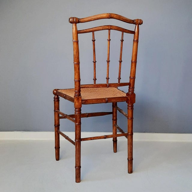 This antique wooden faux bamboo chair originates from France. Wood and rattan are in good condition.