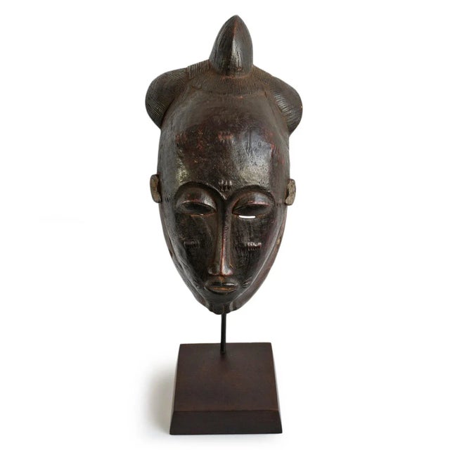 Original Baule Akan ceremony mask. Traditional detailed hair design carvings and facial scarification markings with aged...