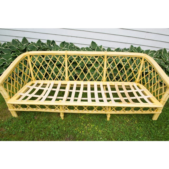 1970s vintage Ficks Reed faux bamboo and rattan sofa with a chinoiserie flair. In original yellow finish with original...