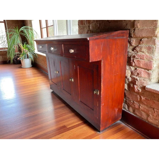 Stained a deep brick red with aniline dye and then varnished. The expected wear and character for a piece that would have...
