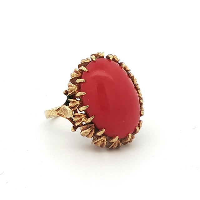 This gorgeous cocktail ring comes from the 1950s and was made in 18k yellow gold with a large red-orange coral. The corals...