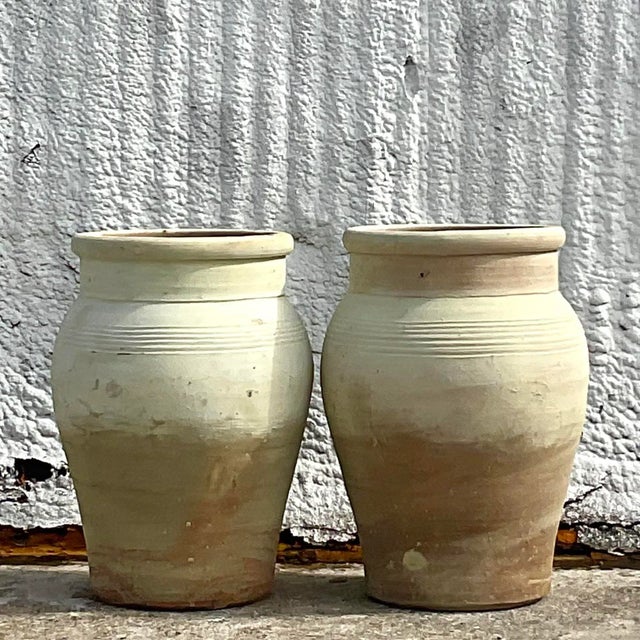 A stunning pair of vintage ripple band Boho urns. A chic terra cotta with a gradient layer of paint. An all over patina...