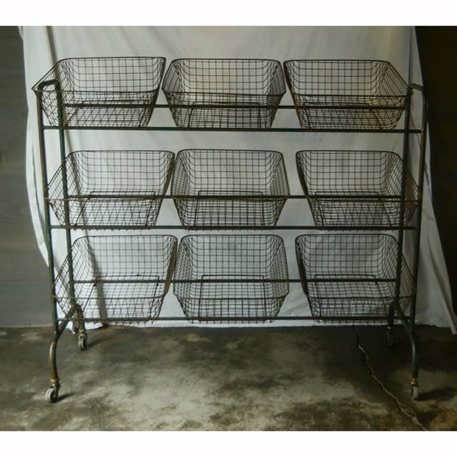 Vintage metal storage rack on casters. Painted green; please see images for detail of surface patina. Nine baskets for...