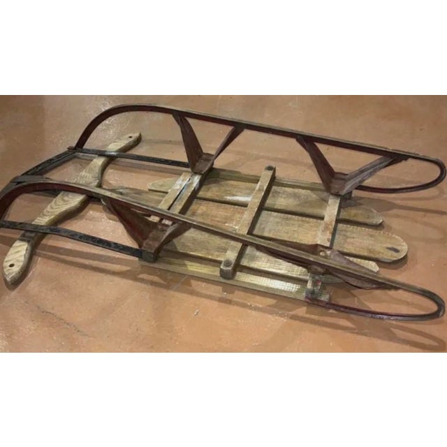 A remarkable piece of mid-century Americana, this authentic 1950s Speedway children's snow sled balances classic winter...