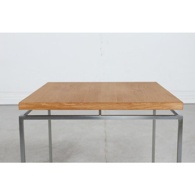 Small side table by Knud Joos for Jason Møbler The table has a frame and legs of thin square steel and a floating table...