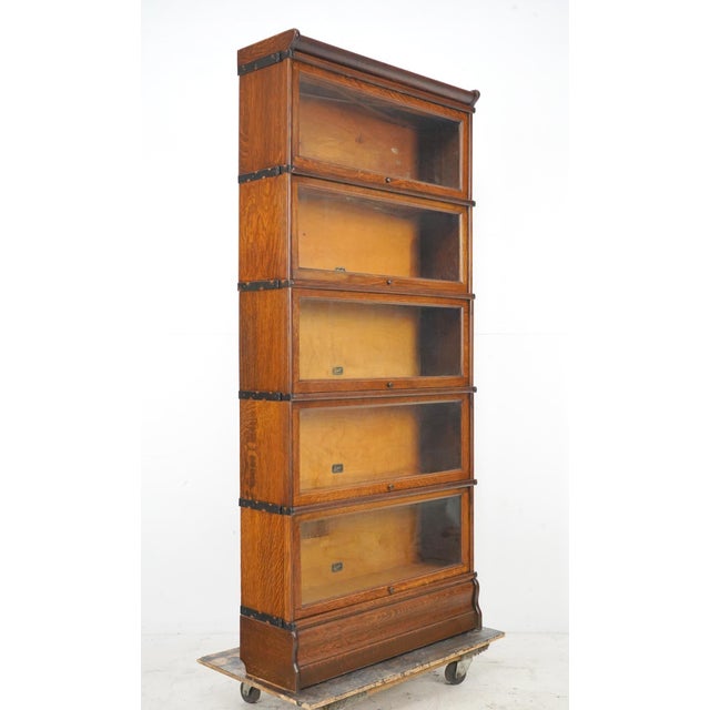 Antique five section oak wood barrister bookcase. It features original japanned steel knobs and braces. Made by Hale in...