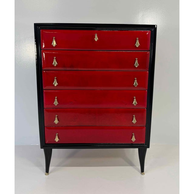 Elegant Italian chest of drawers produced in Italy during the 1950s. The piece features a refined glossy black lacquered...
