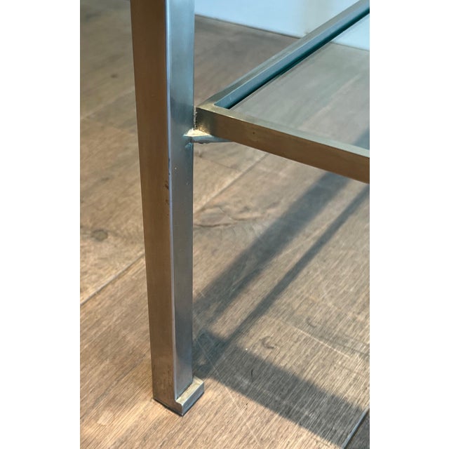 This nice pair of side tables is made of brushed steel with clear glass. The fact the 2 top frames are separated by small...