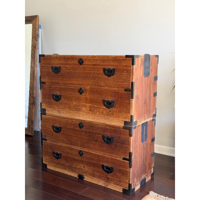 A well-preserved pair of antique Japanese tansu chests, featuring classic Meiji-style construction with warm, richly...