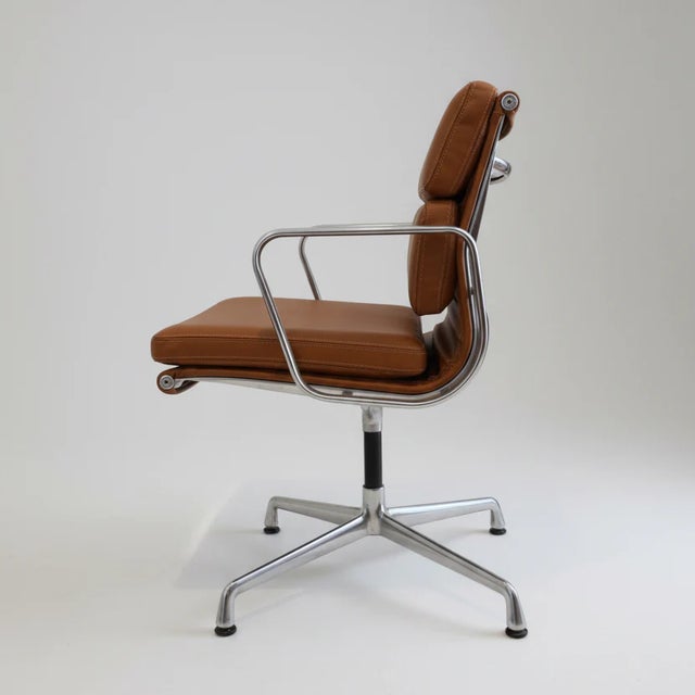 A classic Eames Aluminum Group Side Chair with Arms for Herman Miller, featuring the iconic Soft Pad design and a clean,...