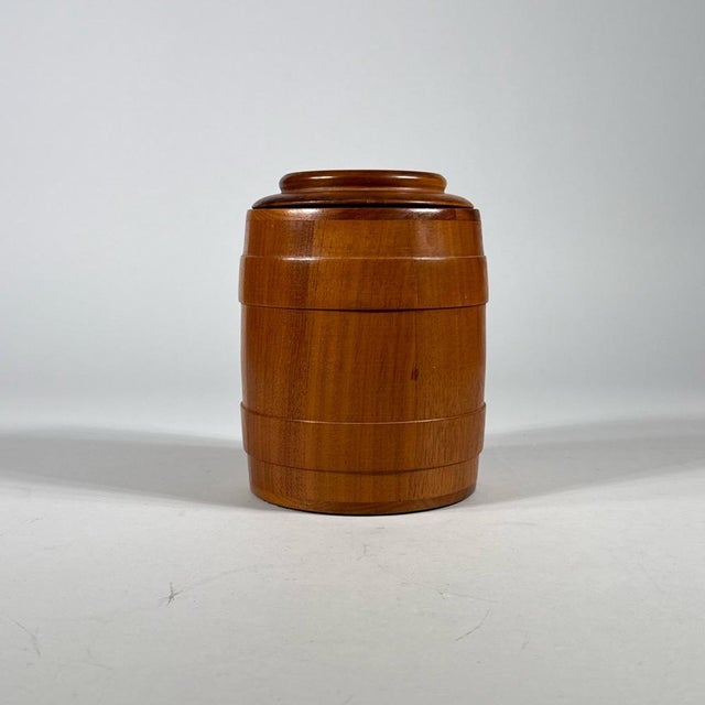 A small turned cigar humidor in the form of a miniature barrel or keg made of a light golden-brown American walnut with a...
