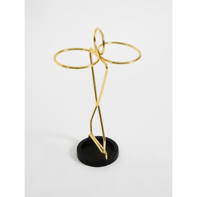 Elegant Mid-Century Modern umbrella stand featuring brass and a black cast-iron base. Minimalist, high-quality design....