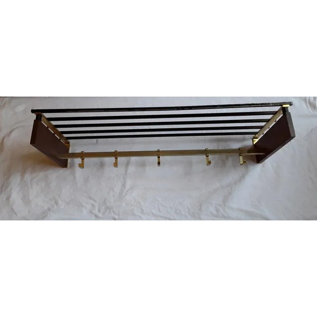 German vintage wall mounted coat rack from the 70's with teak wood cheeks, gold colored sliding metal hooks and black...