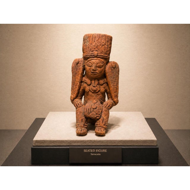 A vintage terracotta seated figure sculpture executed in a Pre-Columbian-inspired style, featuring a tall ceremonial...
