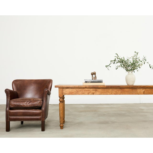 Handsome French art deco style leather club chair with a subtle wingback. The diminutive chair features a hardwood frame...