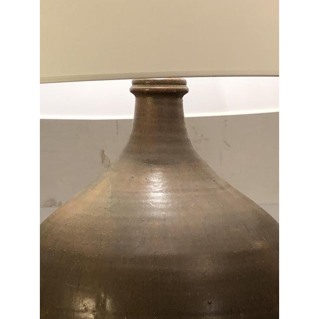 A very large table or floor lamp with a generous, modernist, libre, brutalist, rustic-modern body, in thick sandstone with...