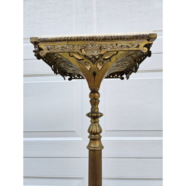 A classic Victorian style brass, cast iron and marble top pedestal plant stand or display piece. This piece has a heavy...
