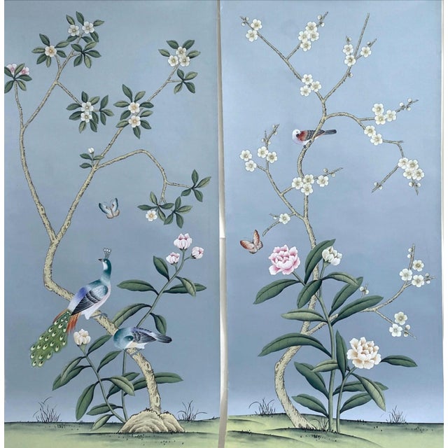 Elegant hand-painted chinoiserie mural set with muted soft blue backdrop, featuring delicate magnolia blossoms, spring...