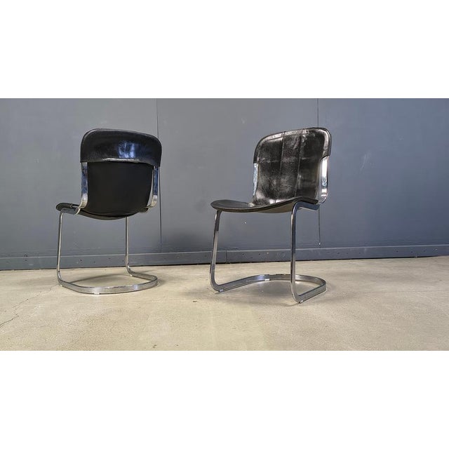 Set of 4 dining chairs from Cidue. The chairs have a beautifully shaped chrome frame and come with the original black...