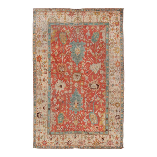 Early 20th Century Antique Turkish Oushak in Tribal Motifs in Soft Coral Blue Marigold and Cream For Sale