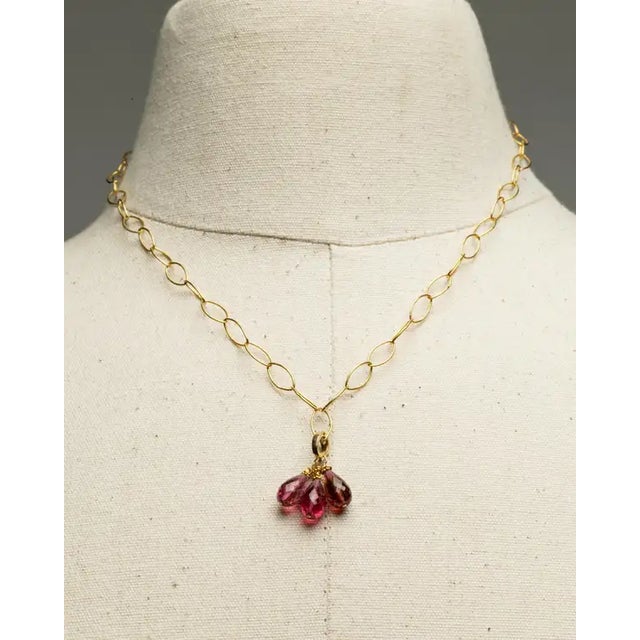 A striking and lovely oval-link, 18K gold chain with a optional gold bail drop. The drop is a cluster of faceted pink...