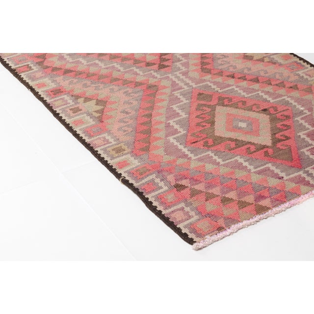 This is a vintage Turkish Oushak rug from the Mid 20th Century. The piece was hand-knotted.