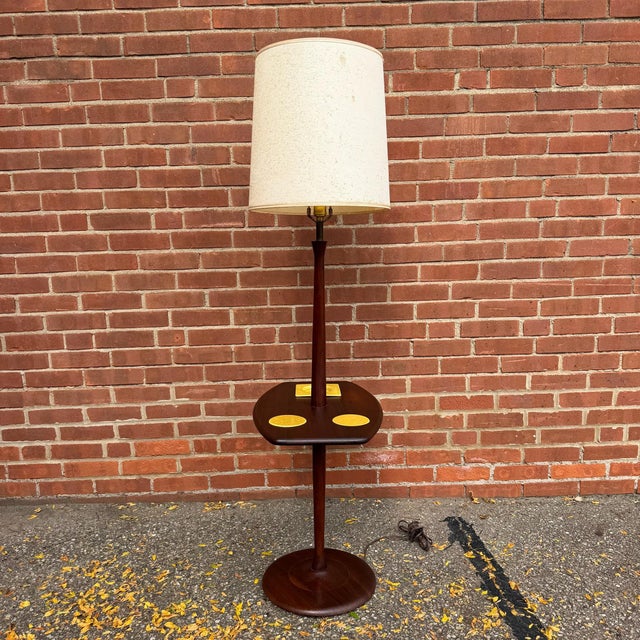 Vintage mid-century modern walnut floor lamp with a built-in table and original ceramic accessories. The rounded...