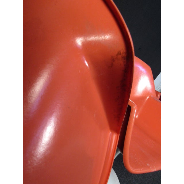 A set of four tulip chairs that pop with Mid-Century Modern style and a bright peach color. A comfortable design sits upon...