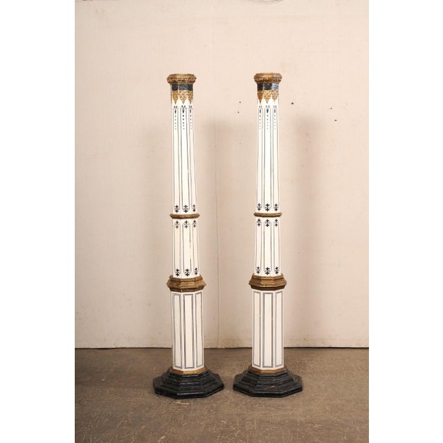 A Spanish pair of tapering, painted wood columns from the early 20th century. This tall pair of antique pillars from...