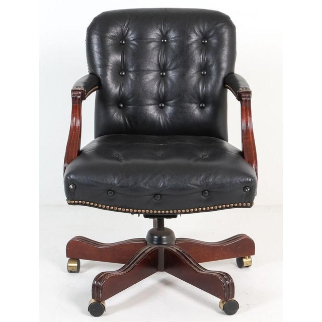 A traditional tufted leather executive office chair. The chair is upholstered in high quality leather and has leather...