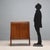 Sideboard with hinged doors, in exotic wood veneer, with decorative inlay thread on the doors, back-treated glass top....
