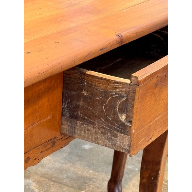 A 19th century French bureau plat in cherry with a rectangular top framed by a wide border. Two drawers open along the...