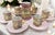 This coffee service is a vintage porcelain set decorated with baroque details. It has a predominantly pink color with gold...