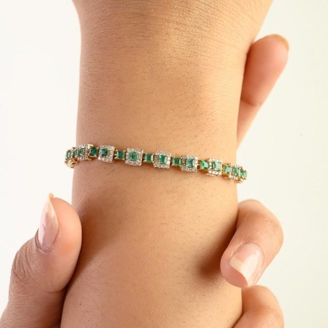 This elegant square link tennis bracelet features 46 square cut natural emeralds totaling 3.12 carats, set in 14k yellow...
