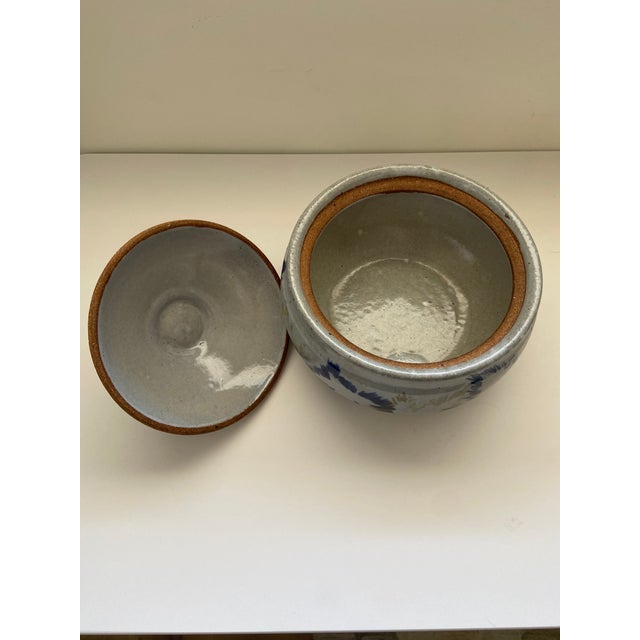 Beautiful ceramic bowl with lid Painted a pale blue/grey with dark blue and green leaves on the outside 8"Diam x 6"H