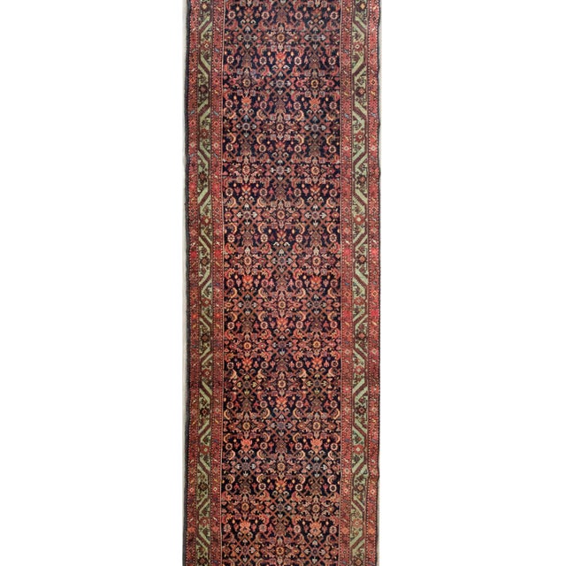 An early 20th century Persian Malayer runner with an all-over trellis floral pattern surrounded by a border with a central...