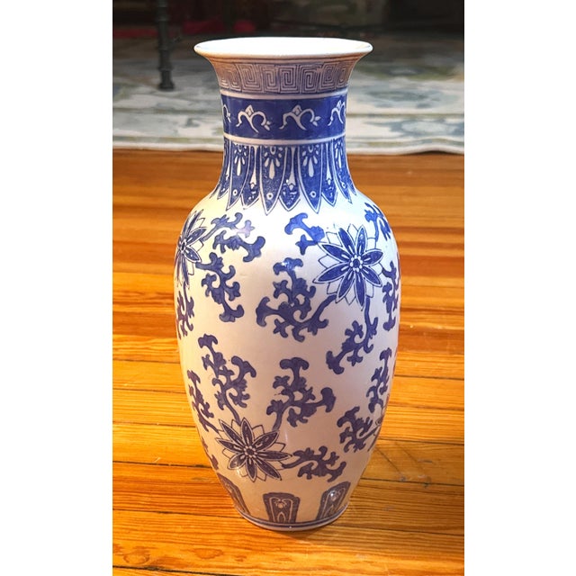 A classic blue‑and‑white Chinese porcelain vase featuring beautifully detailed floral and vine motifs with crisp cobalt...
