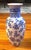 A classic blue‑and‑white Chinese porcelain vase featuring beautifully detailed floral and vine motifs with crisp cobalt...