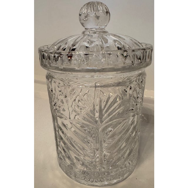 Vintage clear glass lidded biscuit jar featuring a classic cut crystal-style pattern with fan and starburst motifs. This...
