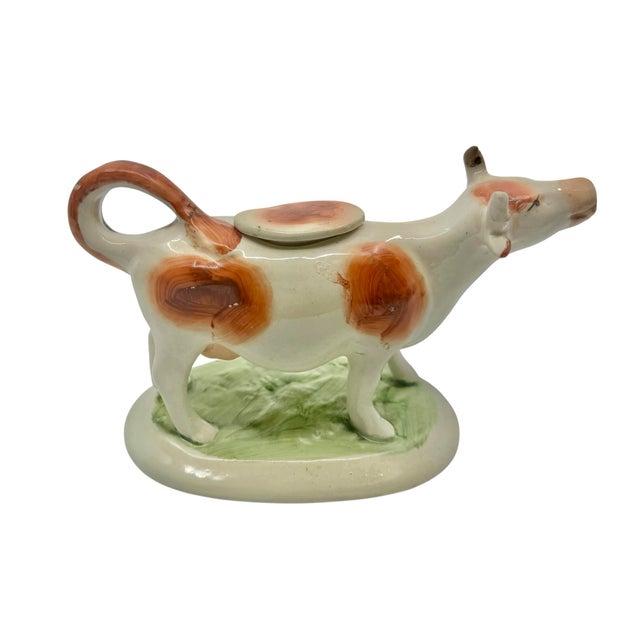 A wonderfully whimsical, 19th century Staffordshire cow creamer, beautifully modeled as a standing dairy cow with a...