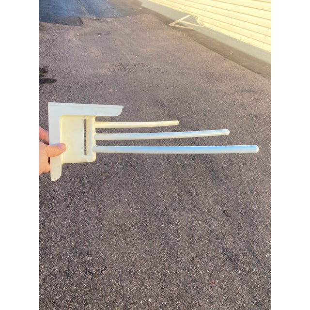 Whimsical, wall-mountable rack for a few scarves, textile samples or hand towels. Three pivoting horizontal bars and...