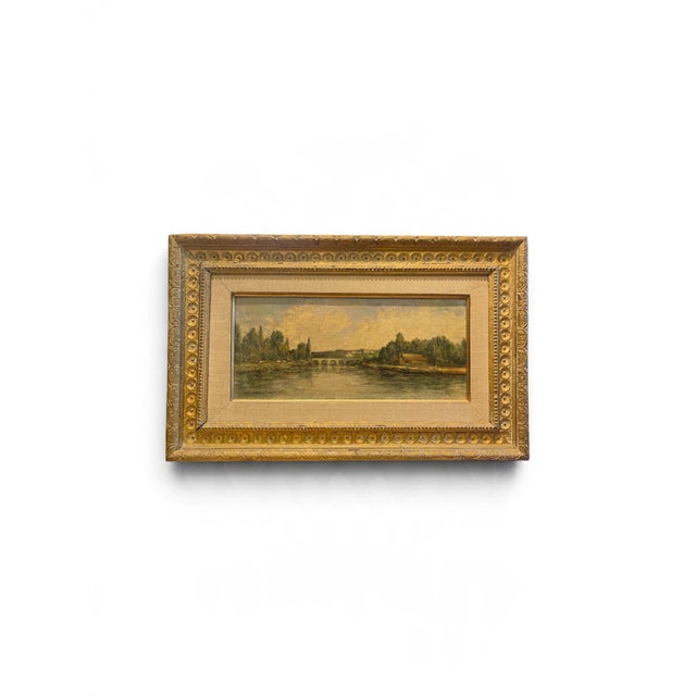 Captivating 19th-century French Barbizon School oil painting depicting a serene, sun-drenched landscape along the River...