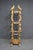 Tall gilt wood and composite etagere display stand with carved scrolling supports and decorative detailing throughout....