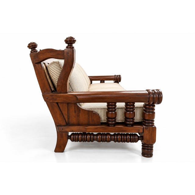 A monumental sofa of commanding architectural presence, executed in a classic carved wood style. Crafted from solid...