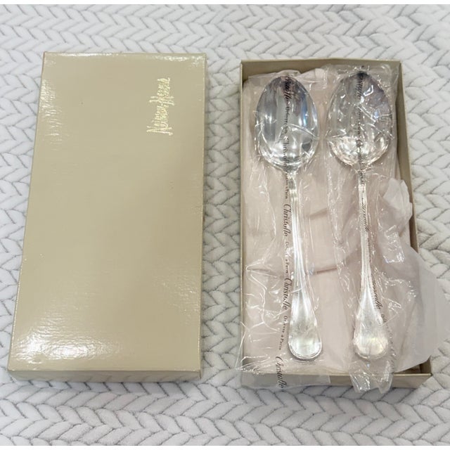 An elegant unused pair of vintage Christofle Albi silver-plated serving spoons from France, presented in a Neiman Marcus...