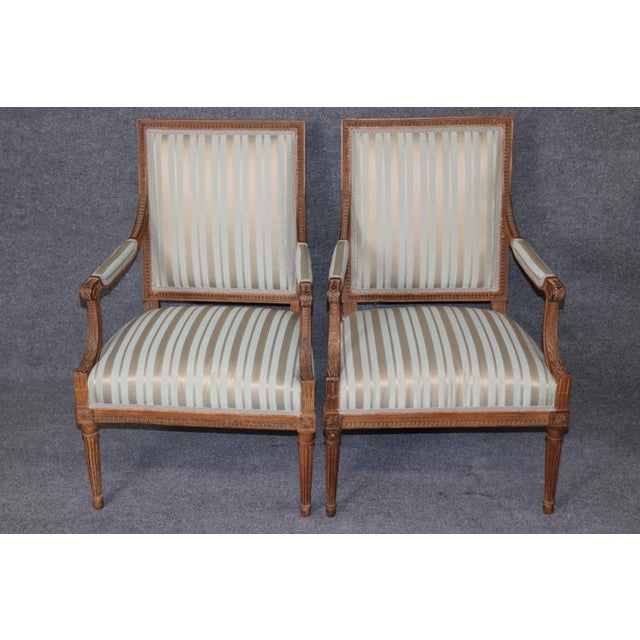An exceptionally elegant and beautifully proportioned pair of genuine French Louis XVI style armchairs, distinguished by...