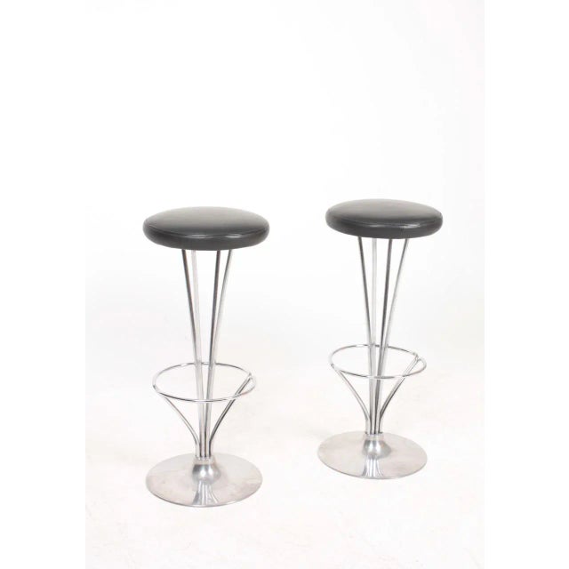Pair of high stools in metal with patinated leather seats. Designed by Piet Hein for Fritz Hansen. Made in Denmark, great...