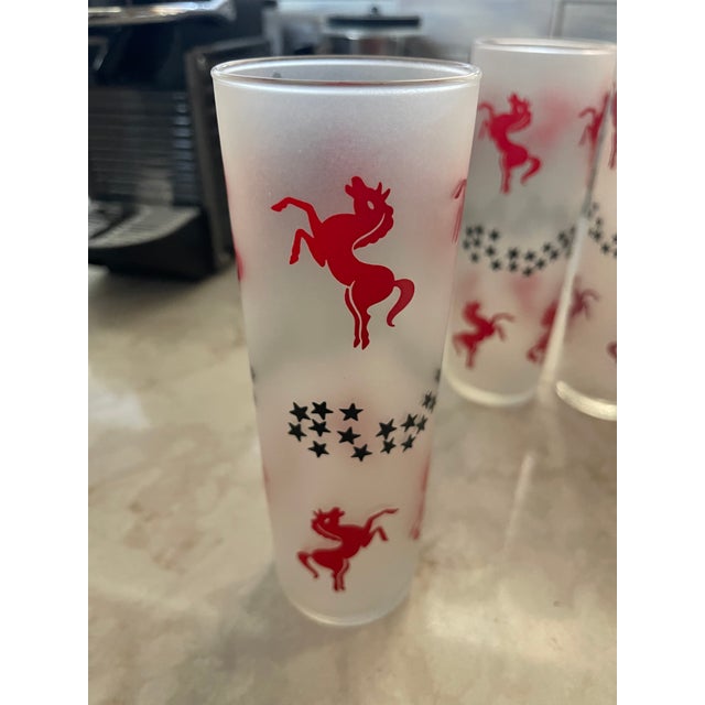 Tom Collins glasses by Libbey from the 1950’s. There are four glasses available. Pattern is Cavalcade with red leaping...